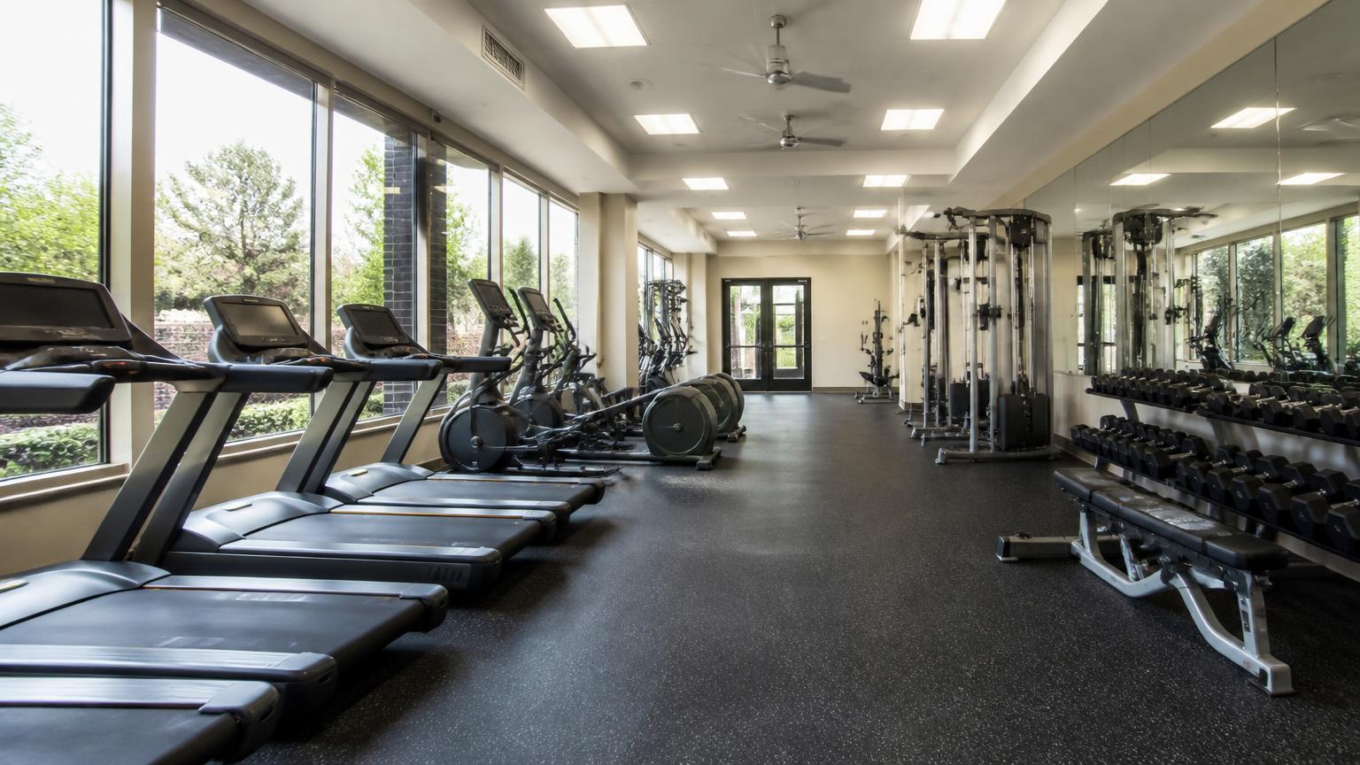 Community fitness center with treadmills, weights and floor-to-ceiling windows